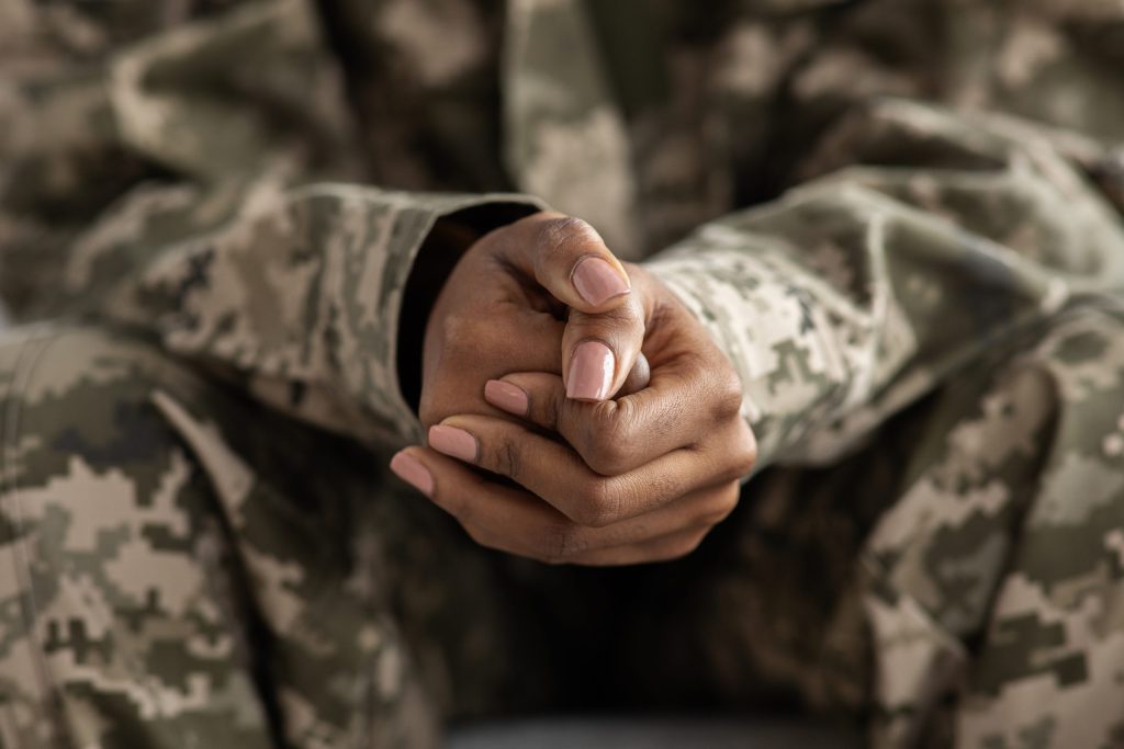 Clasped Hands Of Black Soldier Woman In Camouflage Uniform, Closeup Shot